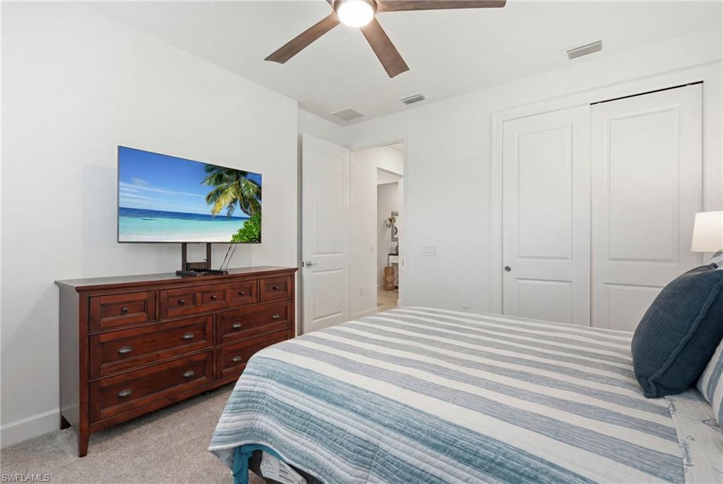 18364 Ridgeline Drive Estero, FL 33928 - Photo 29 of 50 a bedroom with a bed and a flat screen tv