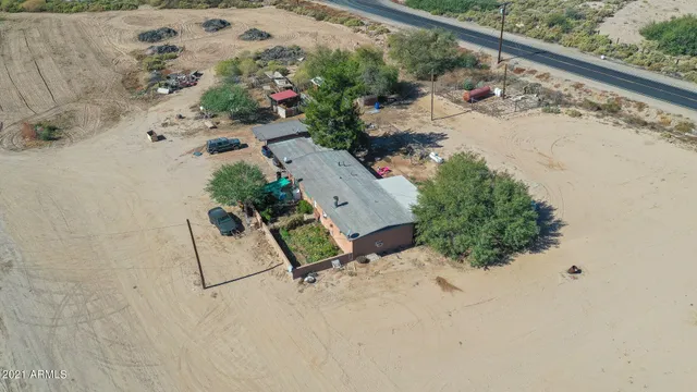an aerial view of a house and a yard with wooden fence