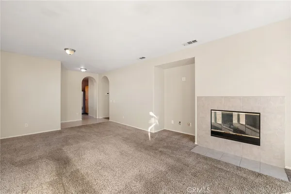 a view of empty room with fireplace and cabinet