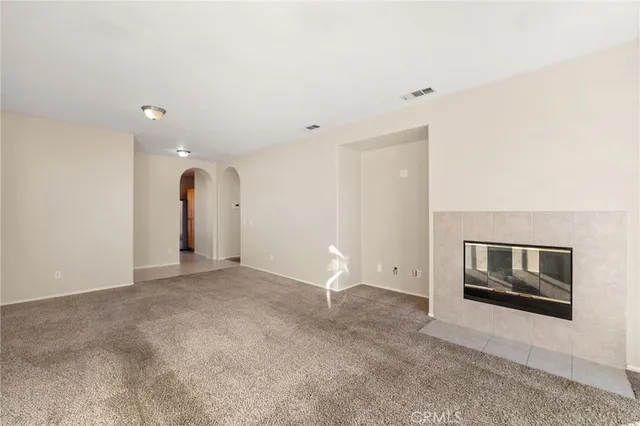 a view of empty room with fireplace and cabinet