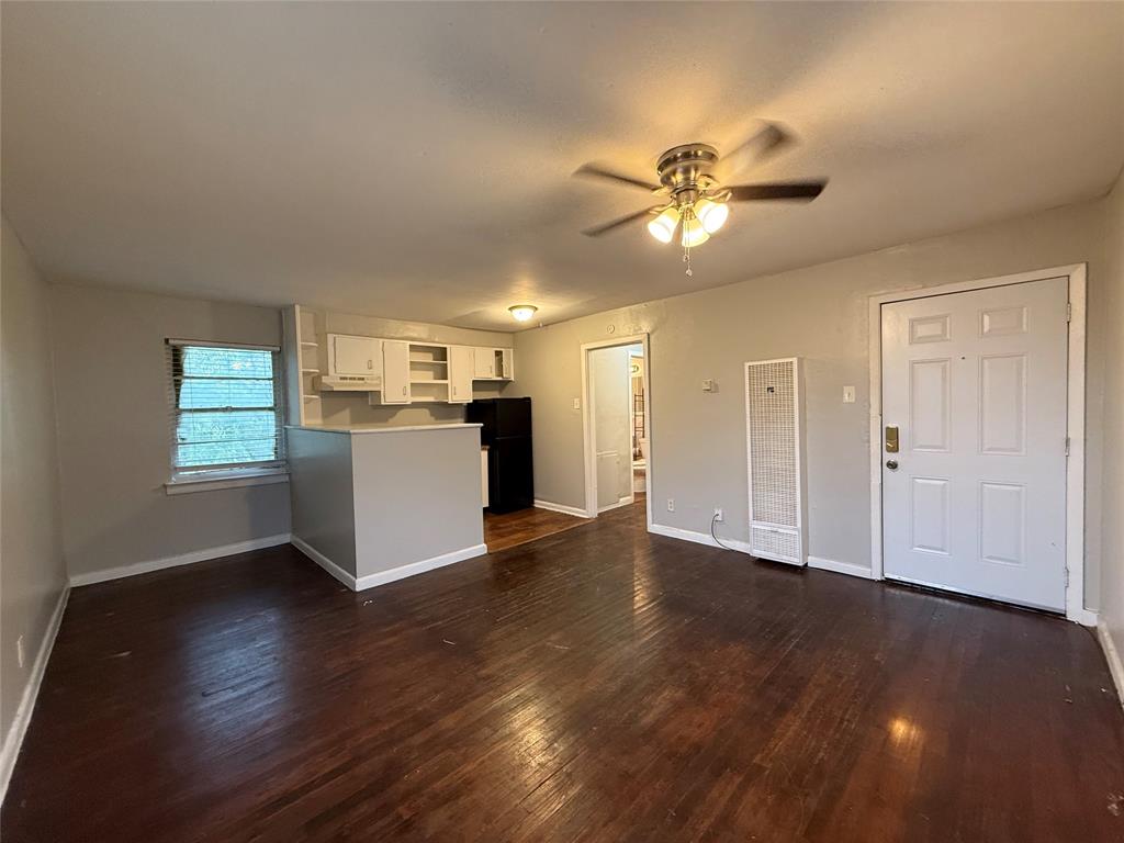 4815 Live Oak Street, Unit 10 Dallas, TX 75204 - Photo 1 of 13 Unfurnished living room with a heating unit, dark wood finished floors, and ceiling fan