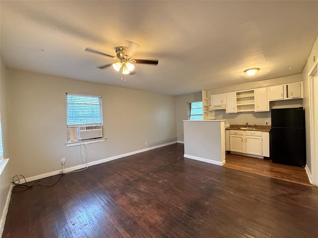 4815 Live Oak Street, Unit 10 Dallas, TX 75204 - Photo 5 of 13 Unfurnished living room with dark wood-style flooring, ceiling fan, and cooling unit