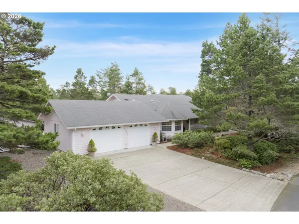 a aerial view of house with yard and trees in the background