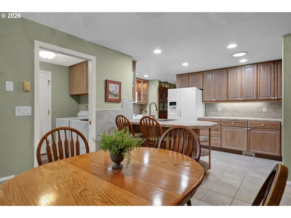 a kitchen with kitchen island a stove a sink a oven with a dining table and chairs