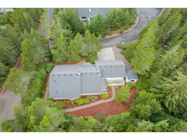 an aerial view of a house with a yard and greenery