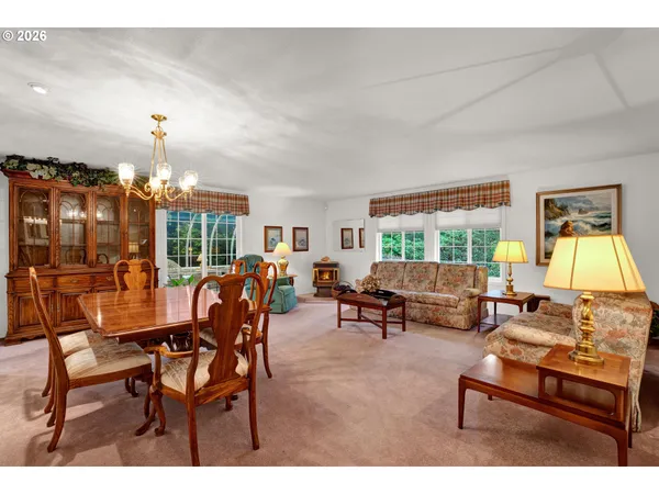 a living room with furniture a chandelier and a dining table