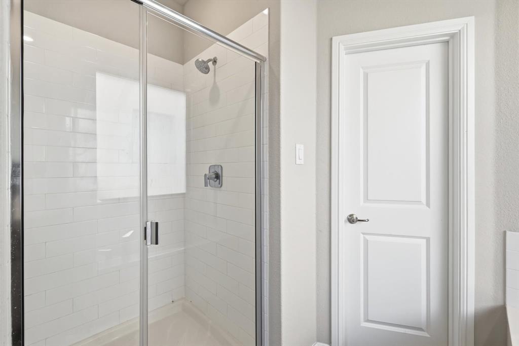 317 Hogan Drive Denton, TX 76210 - Photo 21 of 30 a bathroom with a glass shower door