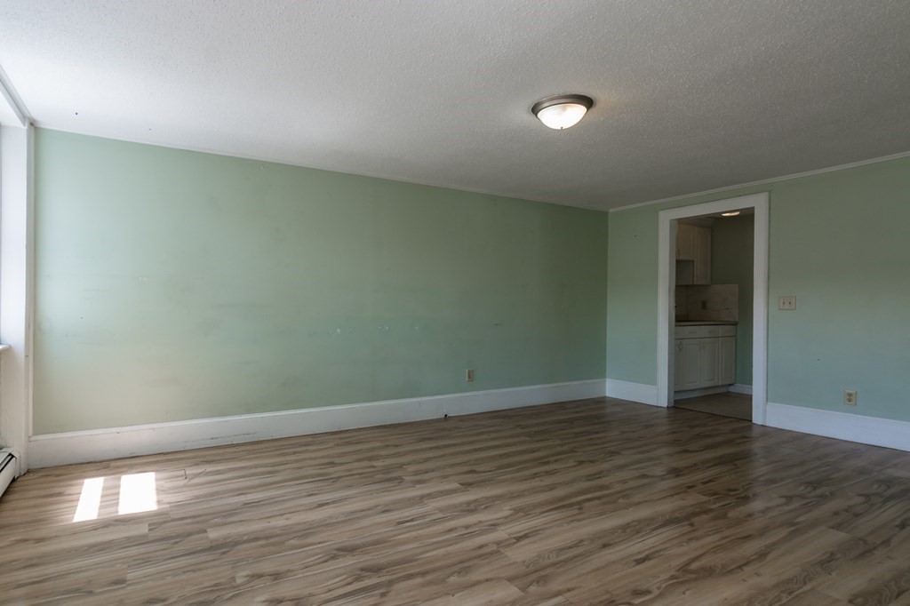 139 Baldwin Street Lowell, MA 01851 - Photo 13 of 39 a view of an empty room with wooden floor and a window