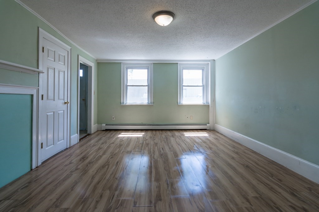 139 Baldwin Street Lowell, MA 01851 - Photo 20 of 39 an empty room with wooden floor and windows