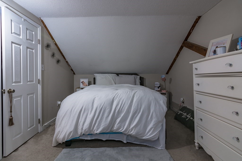 139 Baldwin Street Lowell, MA 01851 - Photo 23 of 39 a bed sitting in a bedroom next to a window