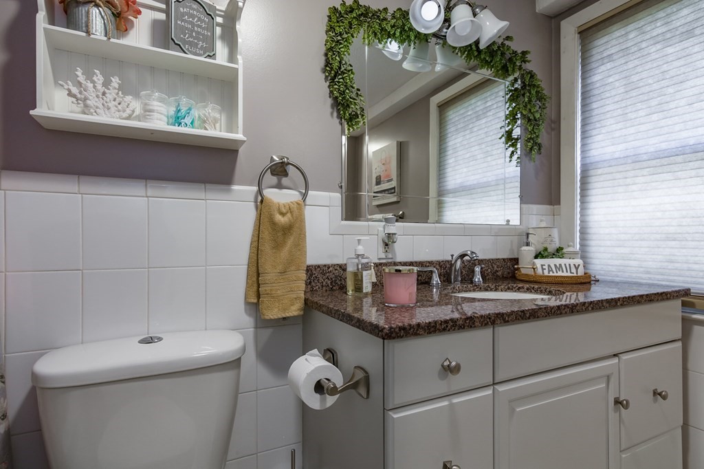 139 Baldwin Street Lowell, MA 01851 - Photo 28 of 39 a bathroom with a granite countertop sink a toilet and a mirror
