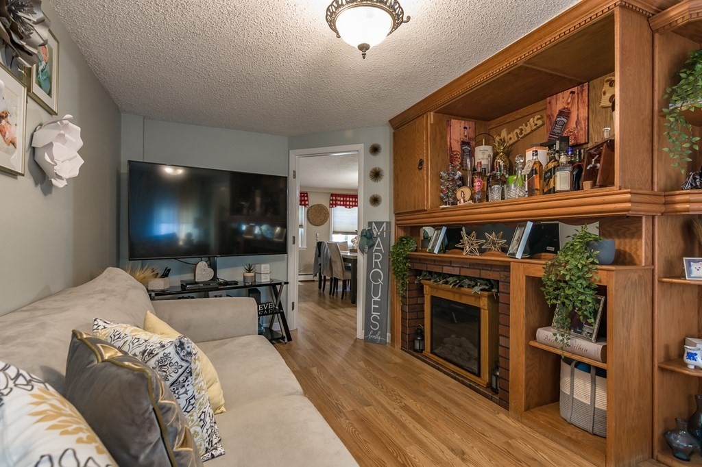 139 Baldwin Street Lowell, MA 01851 - Photo 33 of 39 a living room with furniture a flat screen tv and a fireplace