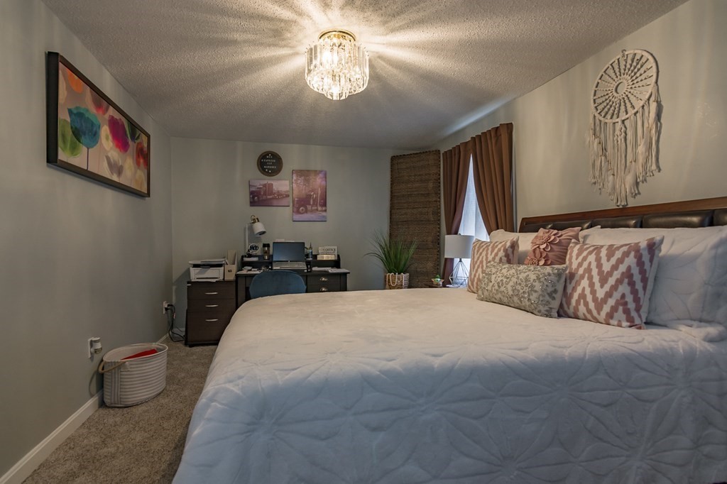 139 Baldwin Street Lowell, MA 01851 - Photo 35 of 39 a spacious bedroom with a bed and a chandelier