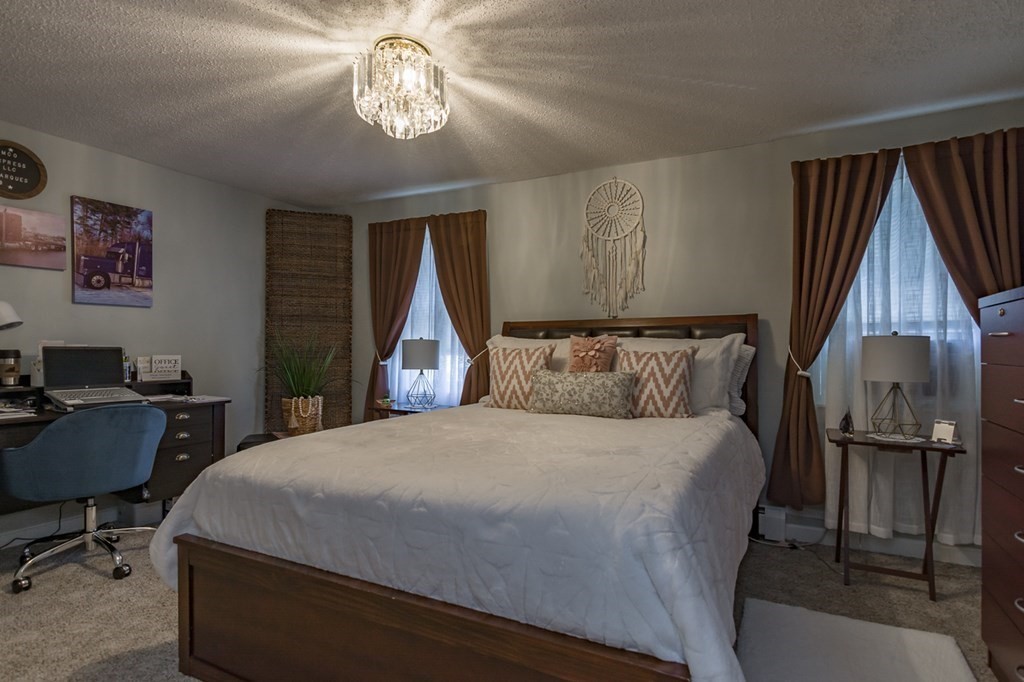139 Baldwin Street Lowell, MA 01851 - Photo 36 of 39 a bedroom with a bed and a chandelier