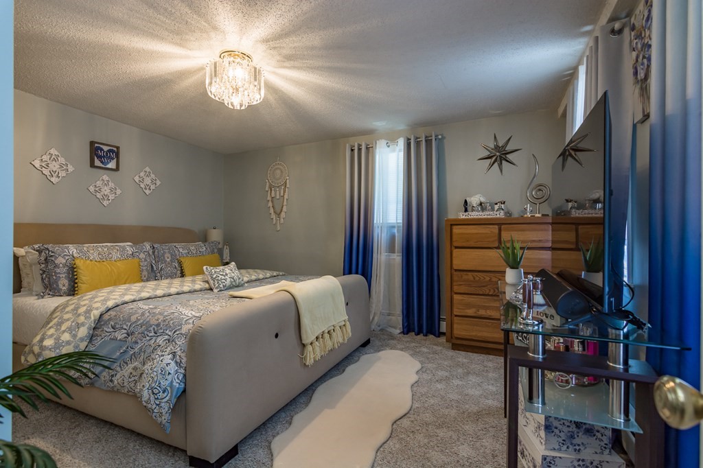 139 Baldwin Street Lowell, MA 01851 - Photo 37 of 39 a bedroom with a bed and a chandelier