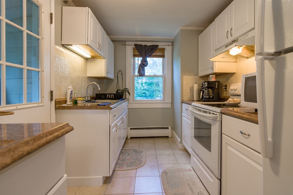 139 Baldwin Street Lowell, MA 01851 - Photo 7 of 39 a kitchen with granite countertop a sink stainless steel appliances and cabinets