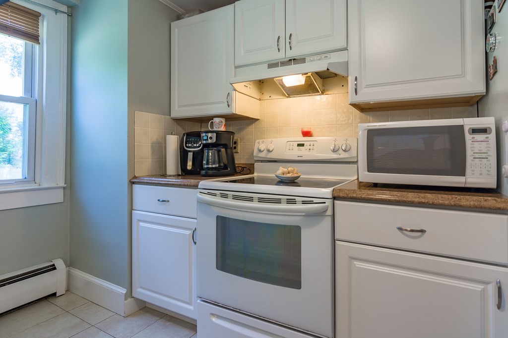 139 Baldwin Street Lowell, MA 01851 - Photo 8 of 39 a kitchen with granite countertop white cabinets and white appliances