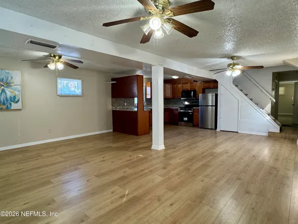 a view of empty room with wooden floor