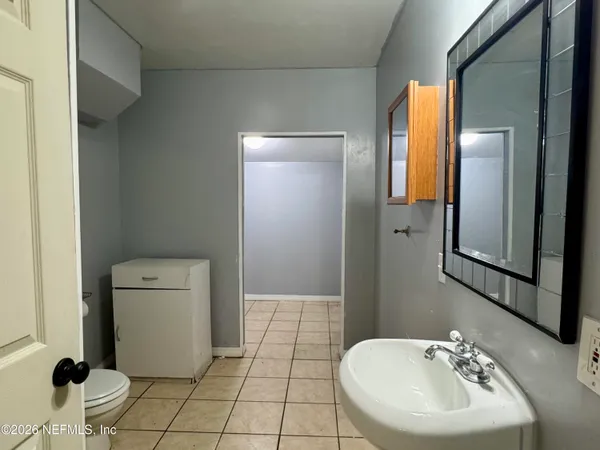 a bathroom with a sink a toilet and mirror