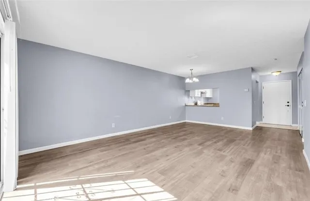 a view of empty room with wooden floor and windows