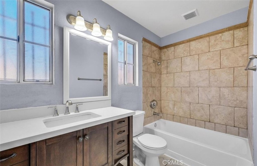 3738 Harrison Street, Unit 31 Riverside, CA 92503 - Photo 14 of 25 a bathroom with a sink a toilet a mirror a bathtub and shower