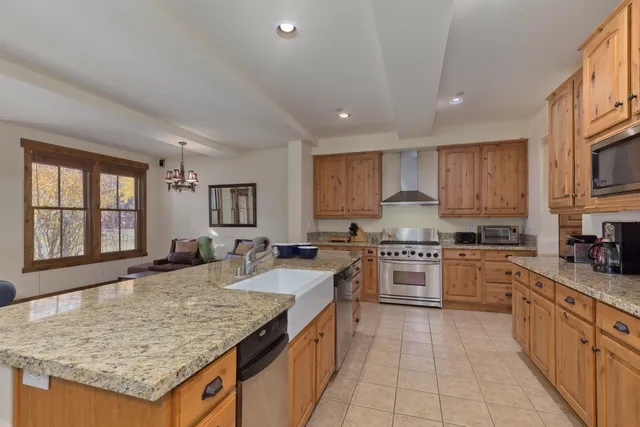 a kitchen with granite countertop stainless steel appliances sink stove microwave and cabinets