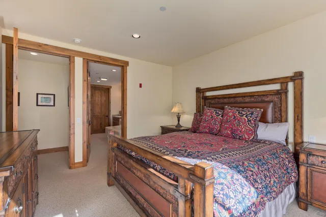 a bedroom with a large bed and a chandelier