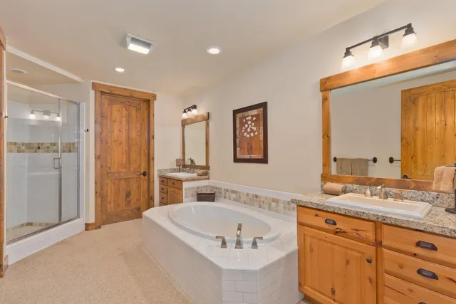 a spacious bathroom with a granite countertop tub sink and mirror