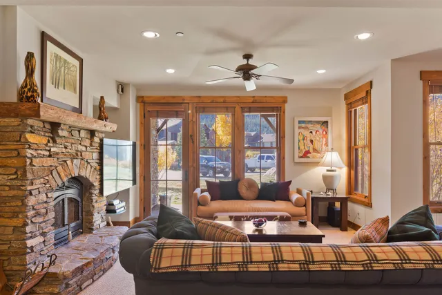 a living room with furniture large window and a fireplace