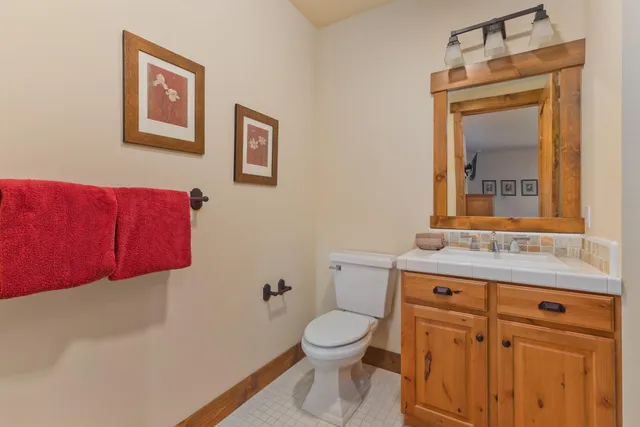 a bathroom with a toilet a sink and mirror