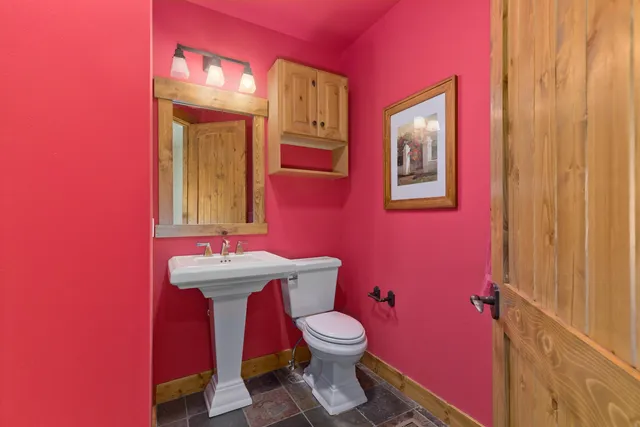 a bathroom with a toilet a sink and mirror