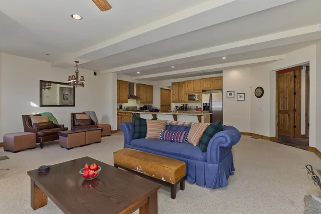 a living room with furniture kitchen view and a window