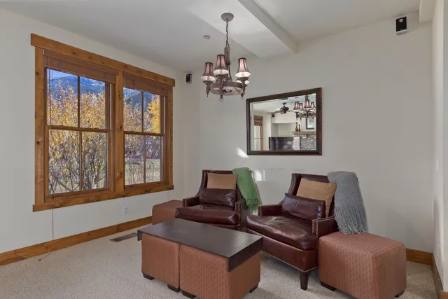 a living room with furniture chandelier and a window