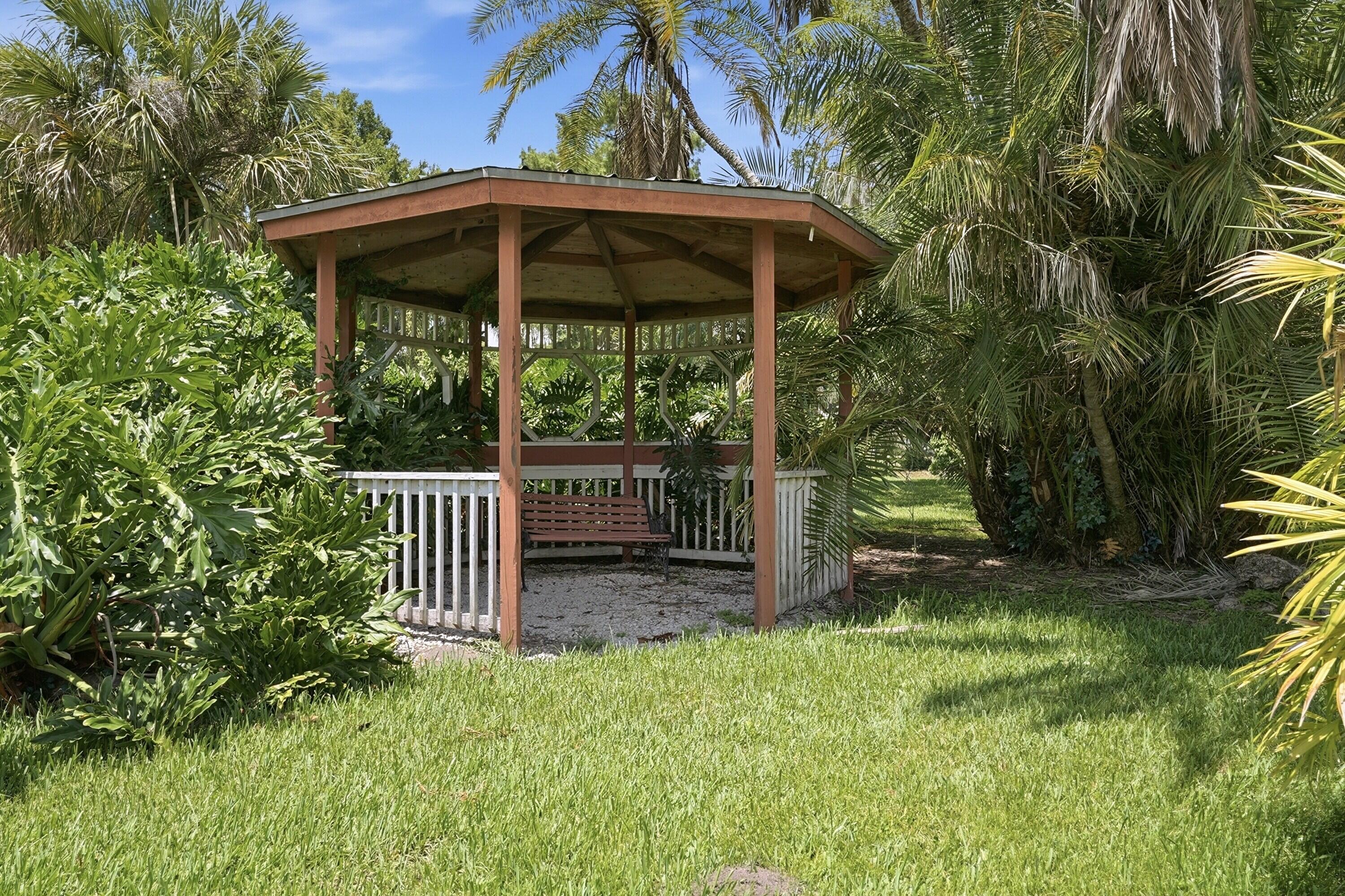 200 Windy Point Road Lake Placid, FL 33852 - Photo 60 of 74 a view of a backyard with a table and chairs under an umbrella