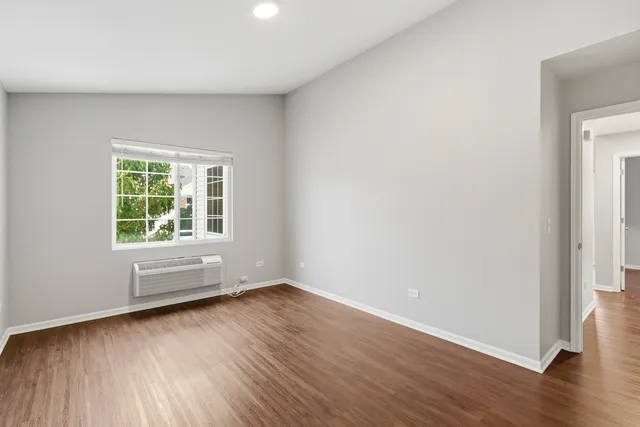 a view of an empty room with wooden floor