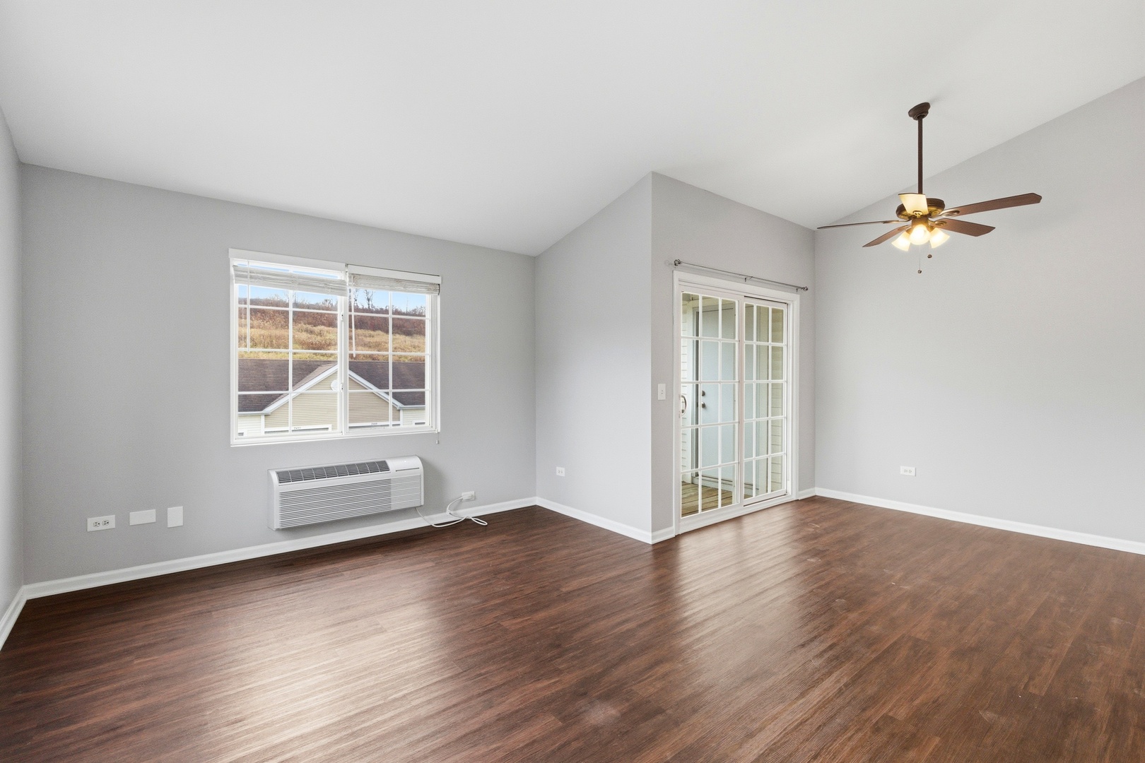 2023 Silverstone Drive, Unit 2023 Carpentersville, IL 60110 - Photo 4 of 19 an empty room with wooden floor cabinet and windows