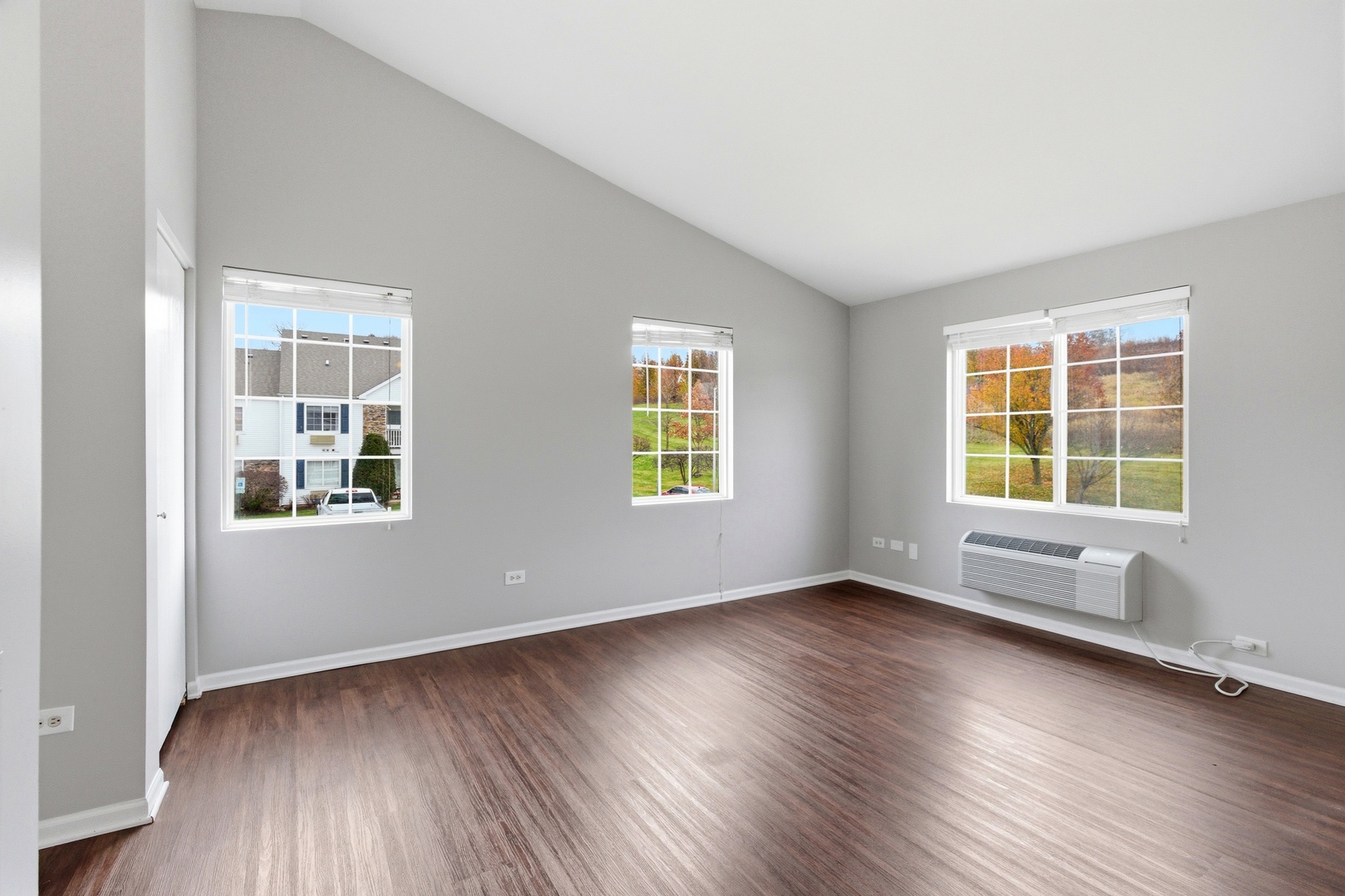 2023 Silverstone Drive, Unit 2023 Carpentersville, IL 60110 - Photo 6 of 19 a view of an empty room with wooden floor and windows