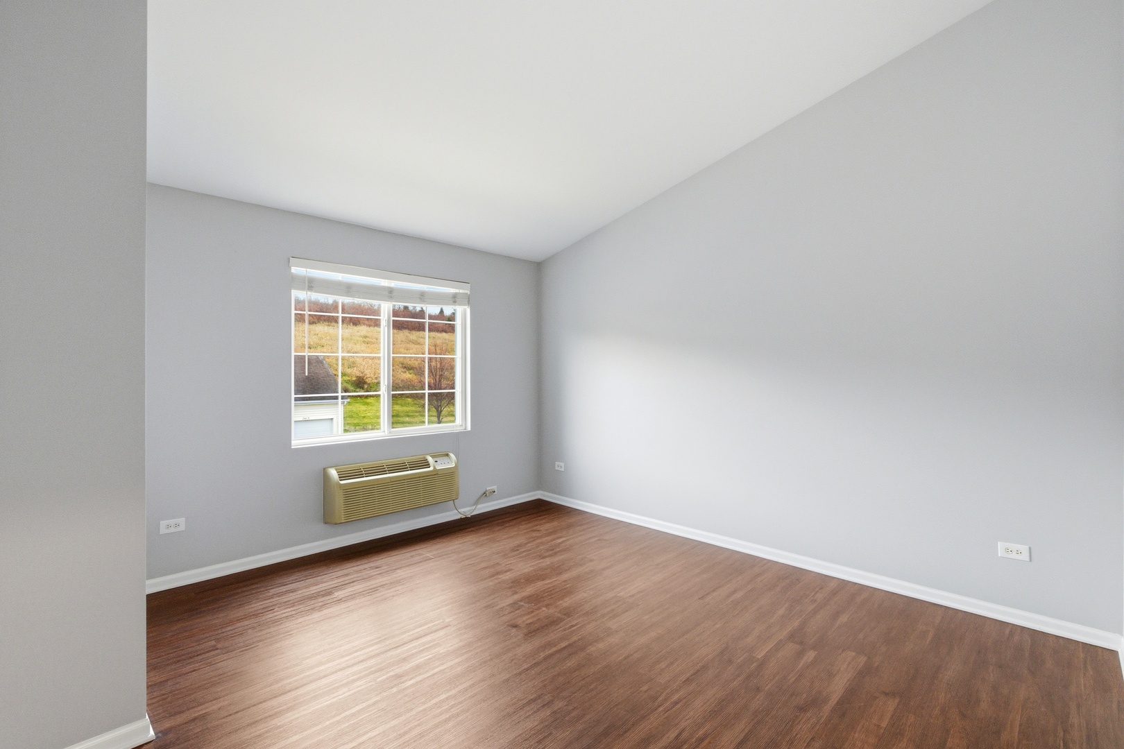 2023 Silverstone Drive, Unit 2023 Carpentersville, IL 60110 - Photo 10 of 19 an empty room with wooden floor and windows