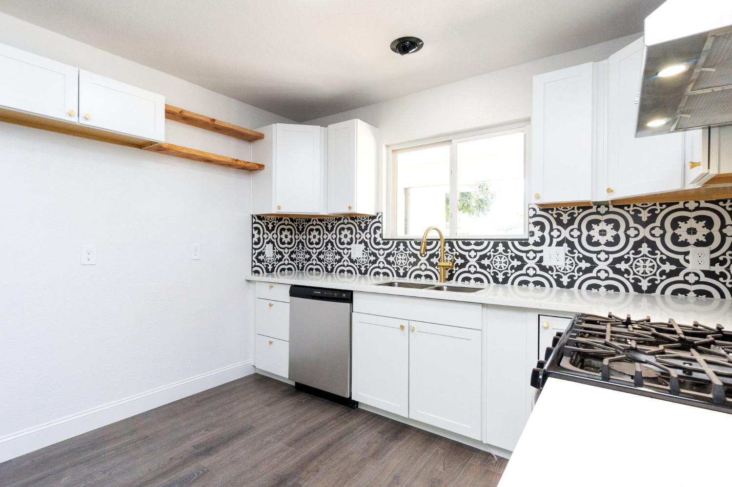 3086 West Hampton Way Fresno, CA 93722 - Photo 11 of 33 a kitchen with granite countertop a sink and a stove