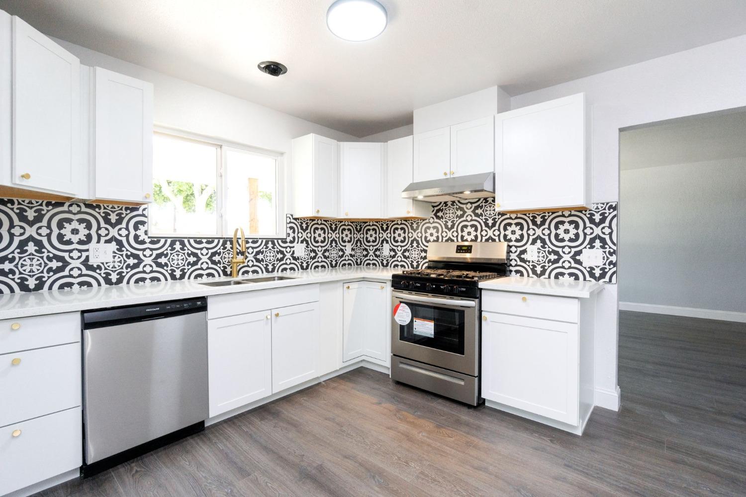 3086 West Hampton Way Fresno, CA 93722 - Photo 12 of 33 a kitchen with granite countertop white cabinets and white appliances