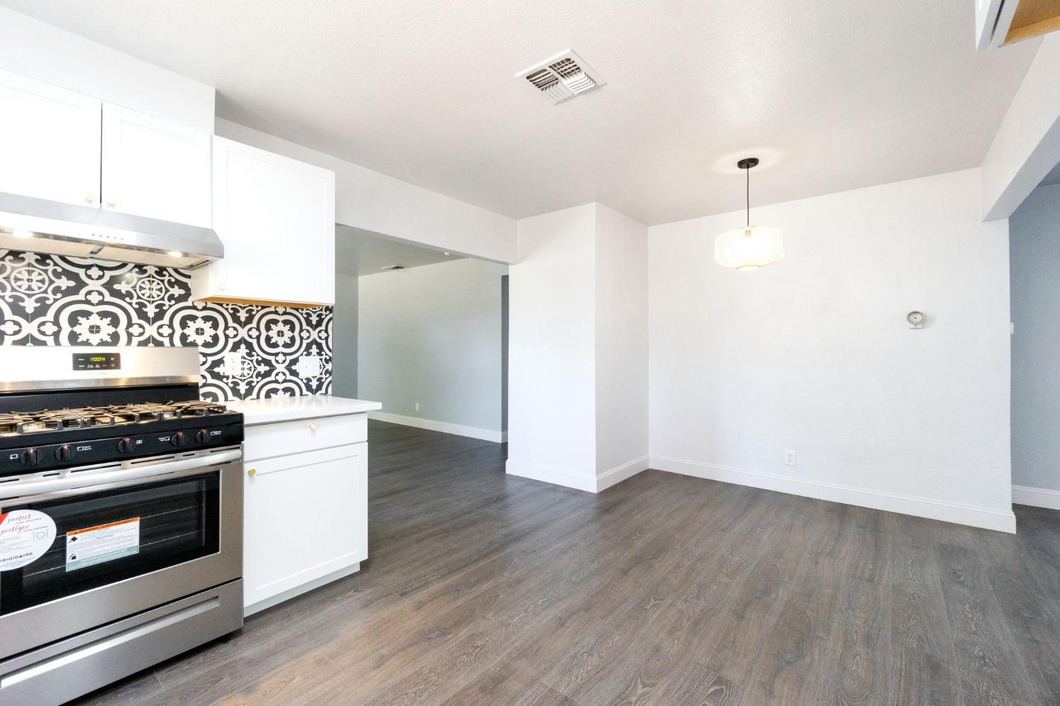 3086 West Hampton Way Fresno, CA 93722 - Photo 14 of 33 a kitchen with a stove and a refrigerator