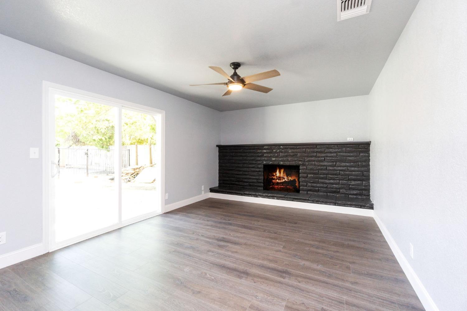 3086 West Hampton Way Fresno, CA 93722 - Photo 16 of 33 a view of an empty room with a fireplace and a window