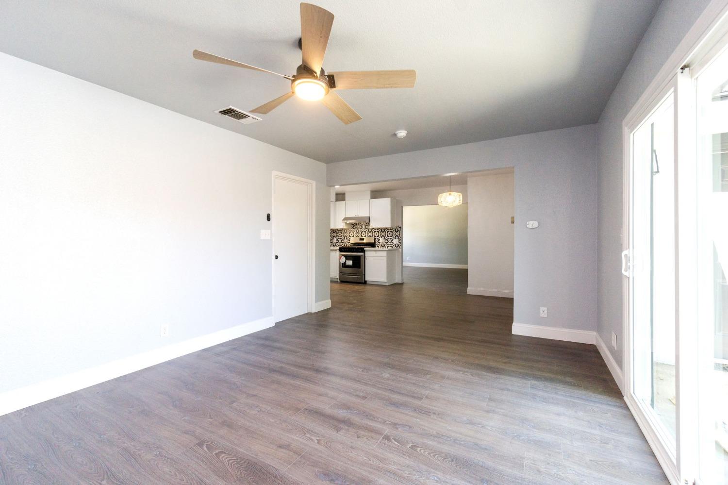 3086 West Hampton Way Fresno, CA 93722 - Photo 17 of 33 a view of an empty room and kitchen with a window