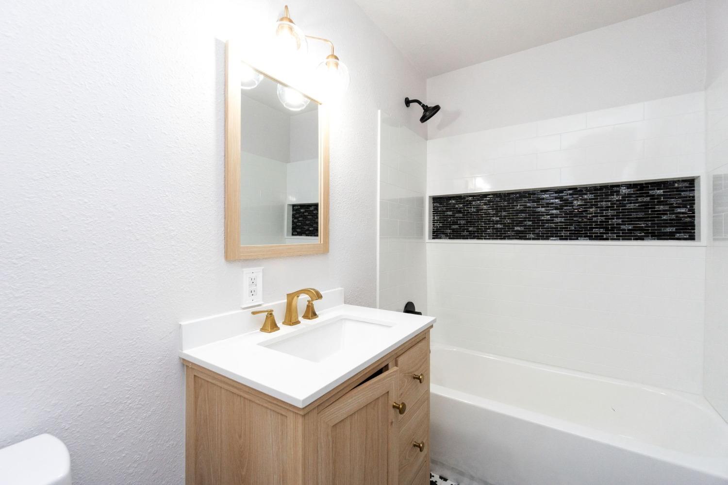 3086 West Hampton Way Fresno, CA 93722 - Photo 18 of 33 a bathroom with a sink a toilet and shower