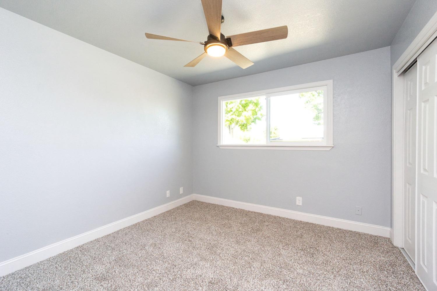 3086 West Hampton Way Fresno, CA 93722 - Photo 19 of 33 an empty room with windows and fan