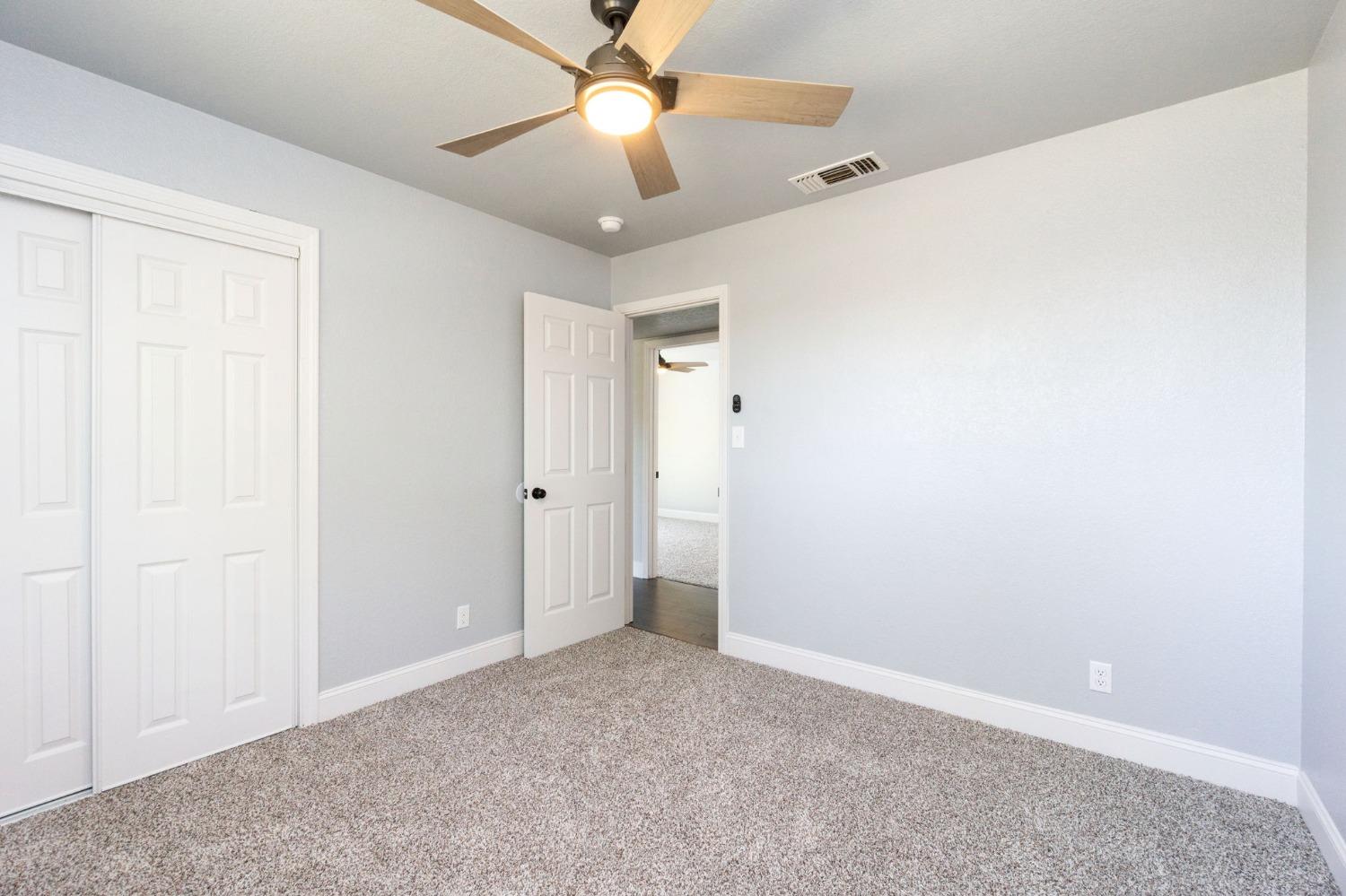 3086 West Hampton Way Fresno, CA 93722 - Photo 20 of 33 an empty room with a ceiling fan and a window