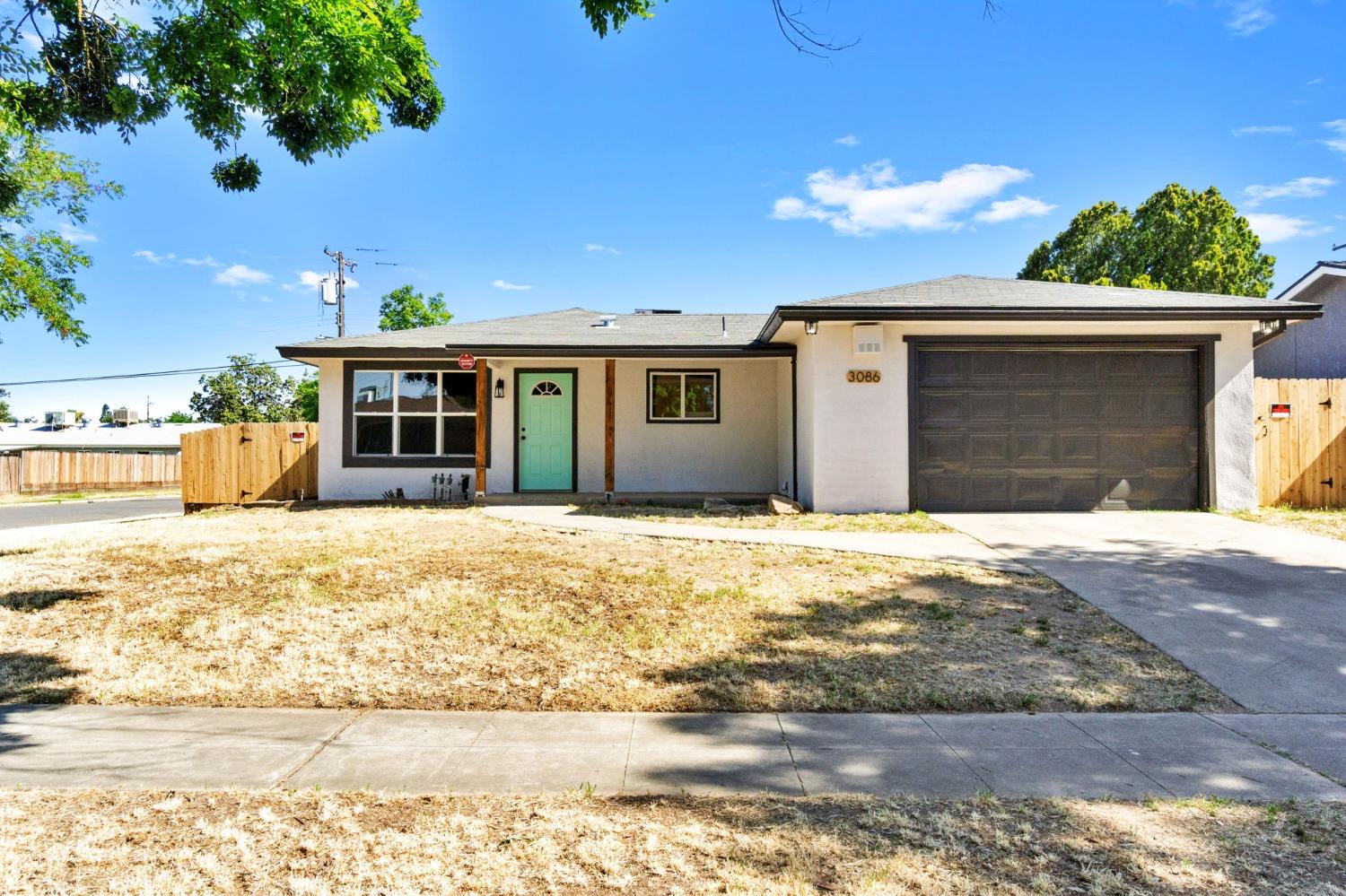 3086 West Hampton Way Fresno, CA 93722 - Photo 2 of 33 a front view of a house with a yard
