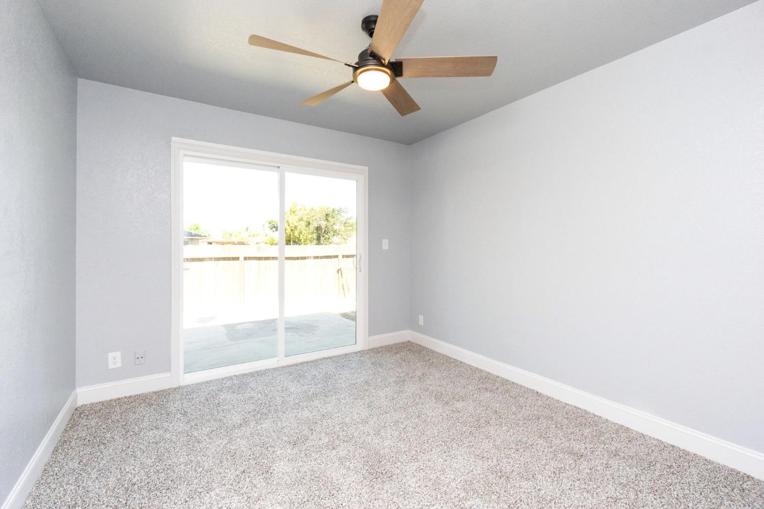 3086 West Hampton Way Fresno, CA 93722 - Photo 21 of 33 an empty room with a window and a fan