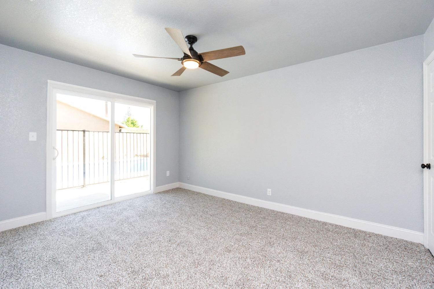 3086 West Hampton Way Fresno, CA 93722 - Photo 24 of 33 an empty room with windows and fan