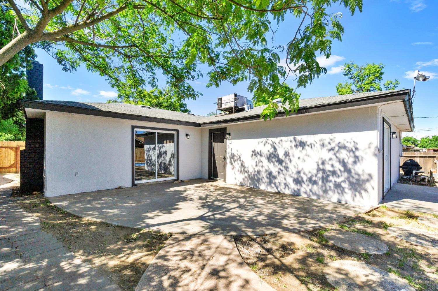 3086 West Hampton Way Fresno, CA 93722 - Photo 27 of 33 a front view of a house with a yard and garage